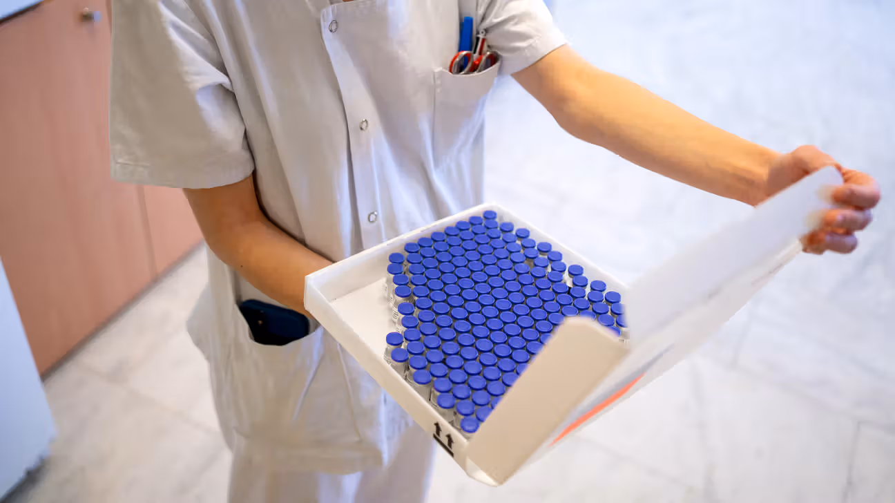 Nurse holding tray of vaccine vials