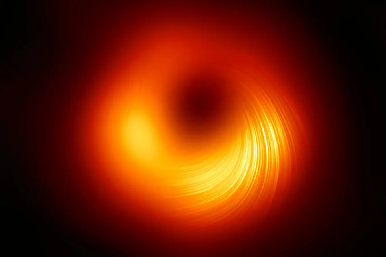 The Event Horizon Telescope (EHT) collaboration, who produced the first ever image of a black hole released in 2019, has today a new view of the massive object at the centre of the Messier 87 (M87) galaxy: how it looks in polarised light. This is the first time astronomers have been able to measure polarisation, a signature of magnetic fields, this close to the edge of a black hole.?? This image shows the polarised view of the black hole in M87. The lines mark the orientation of polarisation, which is related to the magnetic field around the shadow of the black hole.