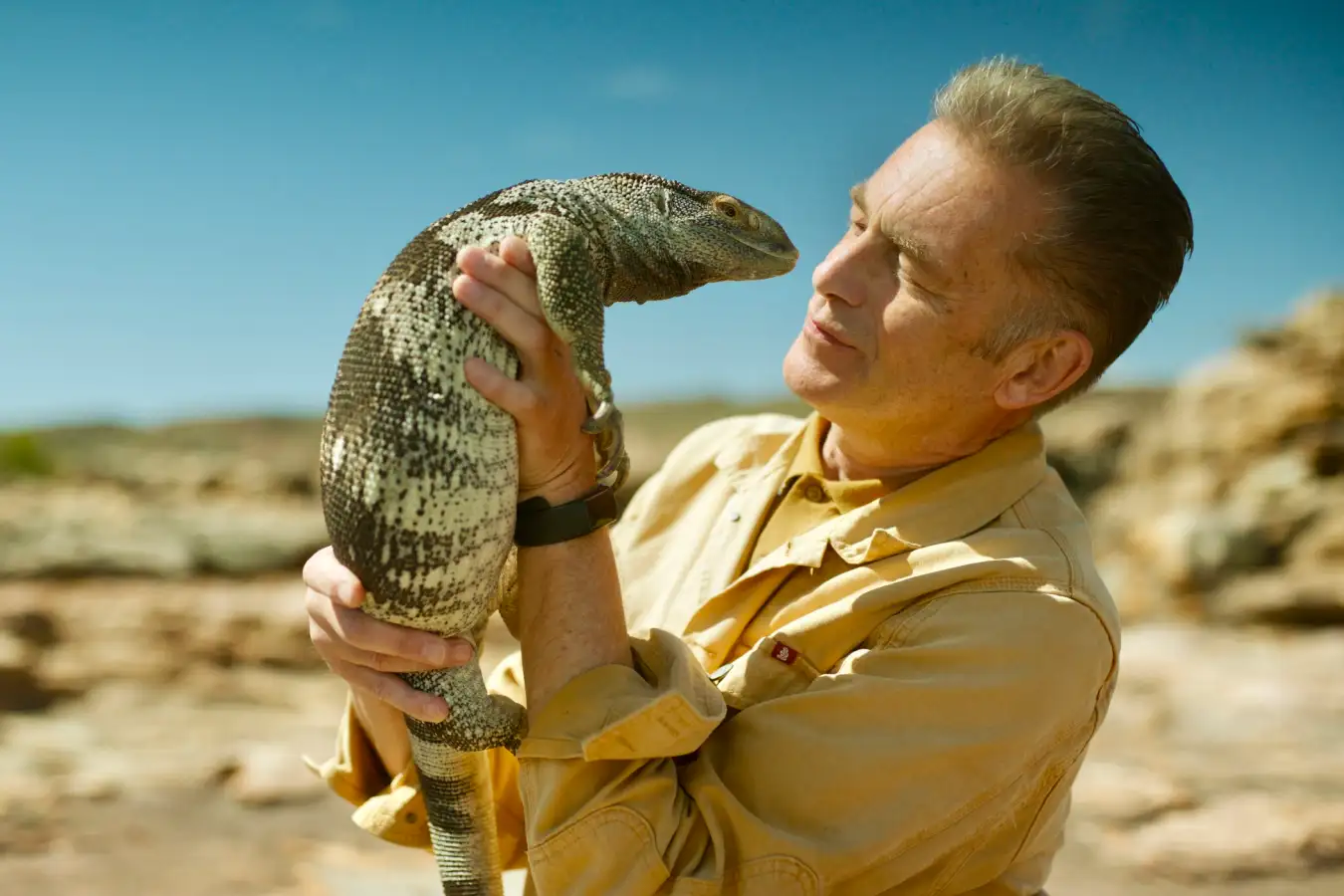 Chris Packham holding a rock monitor lizard in South Africa