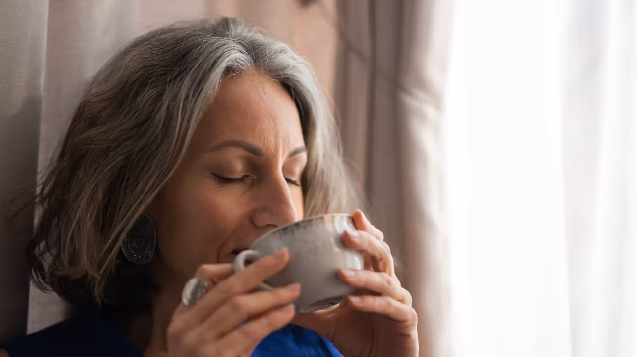 Older female drinking a cup of coffee