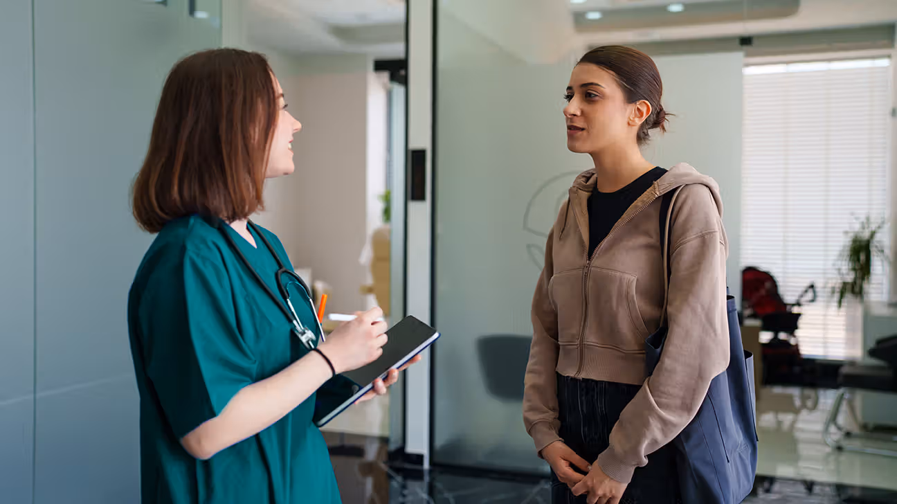 Young female patient talks with healthcare worker